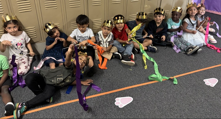 students holding ribbon and crowns