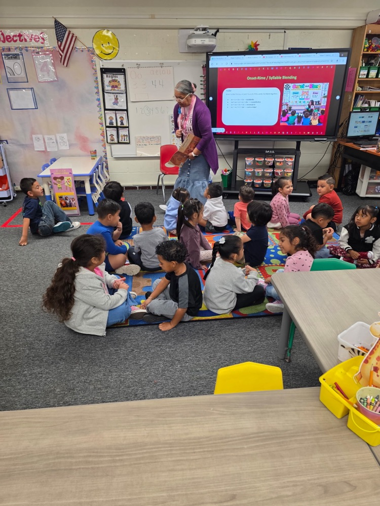 students sitting in class on the floor learning