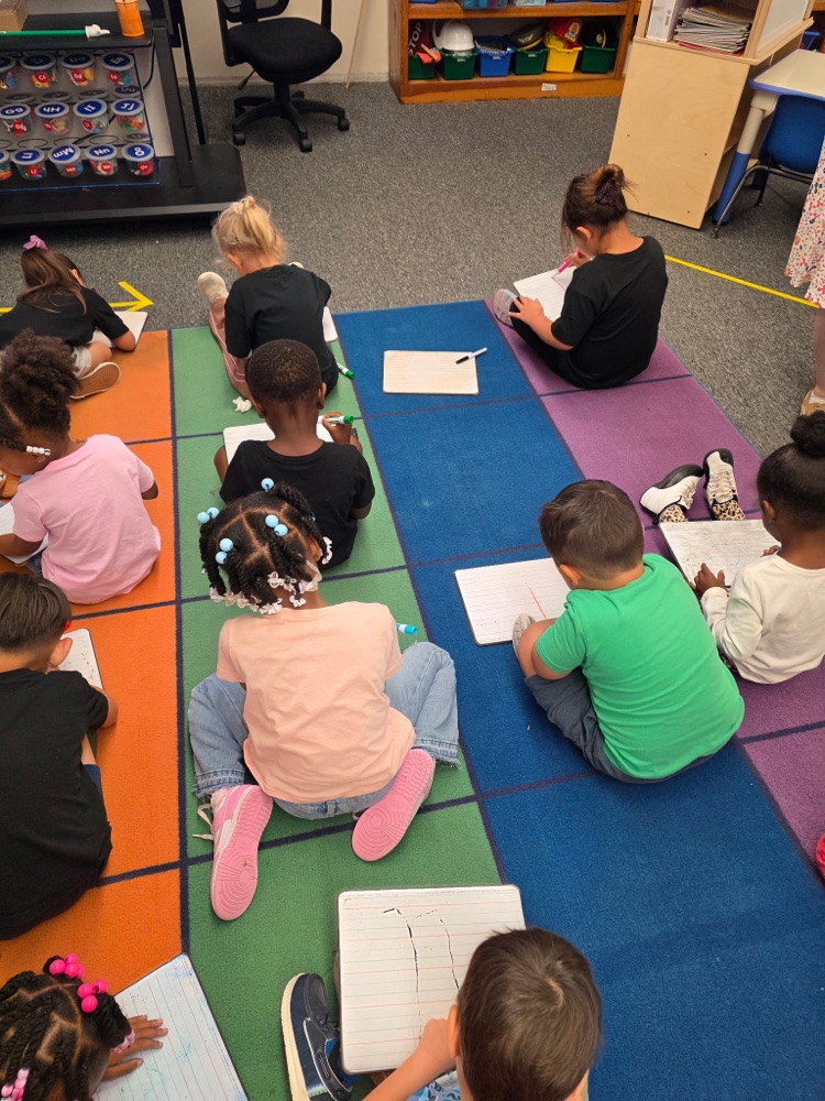 students sitting in class on the floor learning