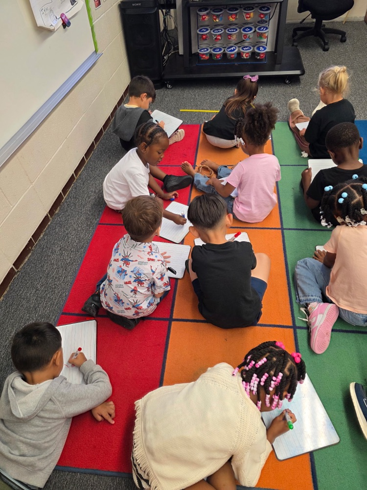 students sitting in class on the floor learning