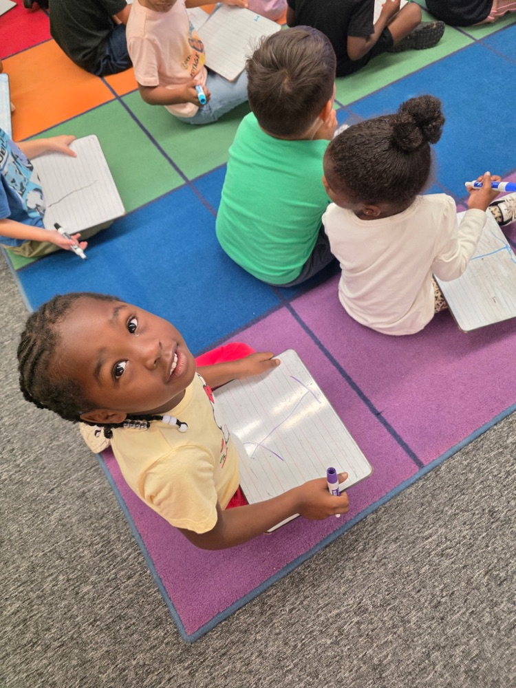 students sitting in class on the floor learning