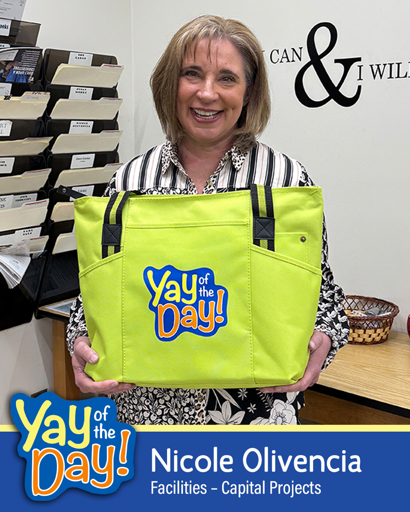 Yay of the Day  graphic showing Nicole Olivencia of Facilities – Capital Projects. She  is smiling and holding up her Yay of the Day bag.