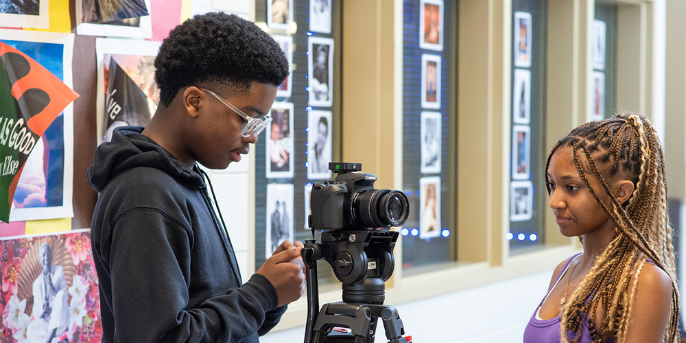 Two students set up a camera at the Center for Communications and Media Relations at Varina High School.