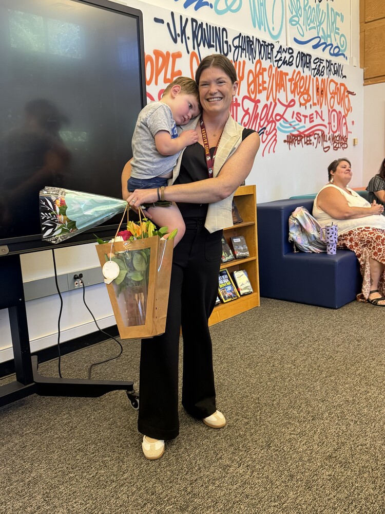 Ciara-Sowers-winning-teacher-of-year-with-flowers-and-child