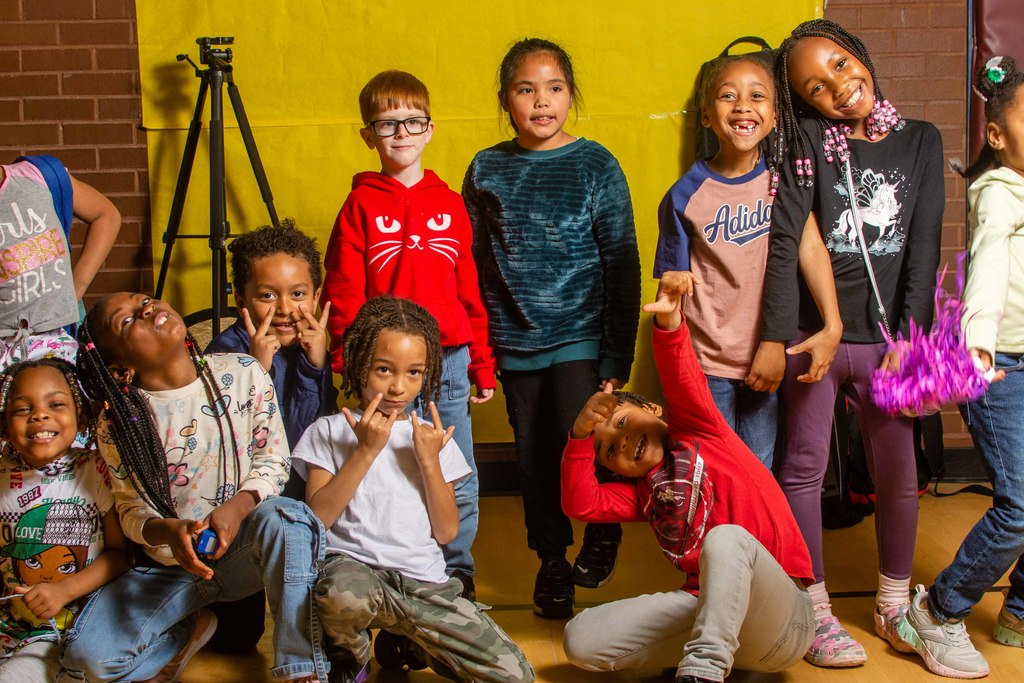 A class of first grade students pose for the camera with smiles