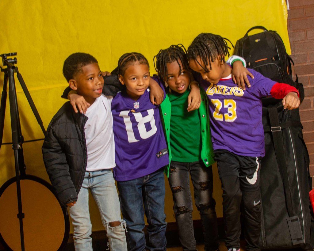 4 students have arms around each other in front of the camera.