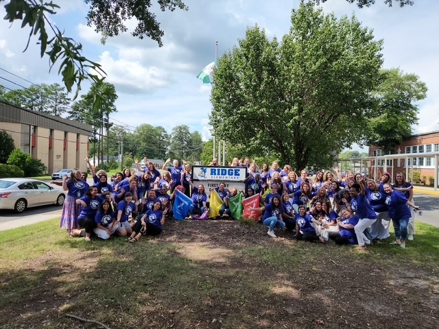 The photo shows Ridge Elementary staff being silly to welcome our students back by the elementary school sign!