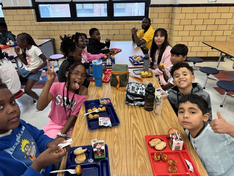 students grin and make silly faces at a cafeteria table