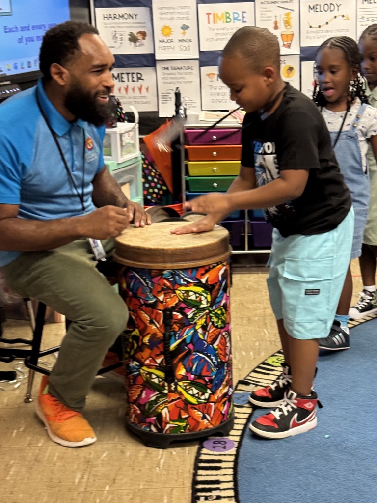Student drums with the music teacher.