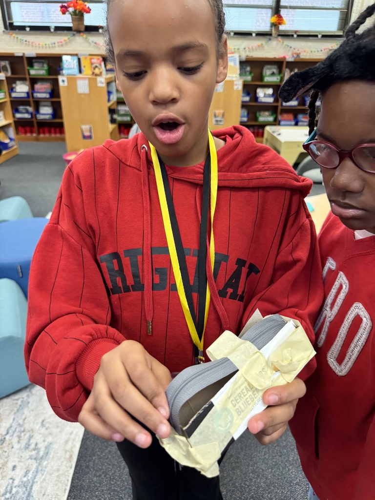 A student shows her giraffe feeder which includes a zipper for opening and closing.