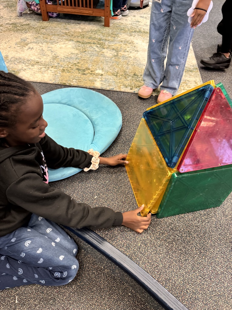 A 2nd grade student shows a place she build for an animal with a door that opens and shuts.