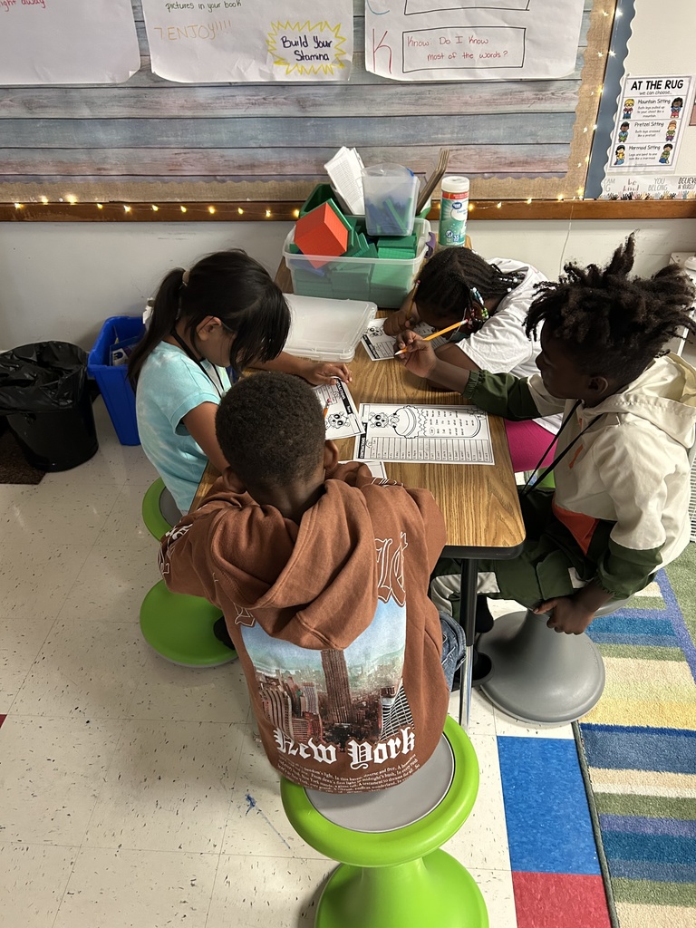 Students sit around a table working.
