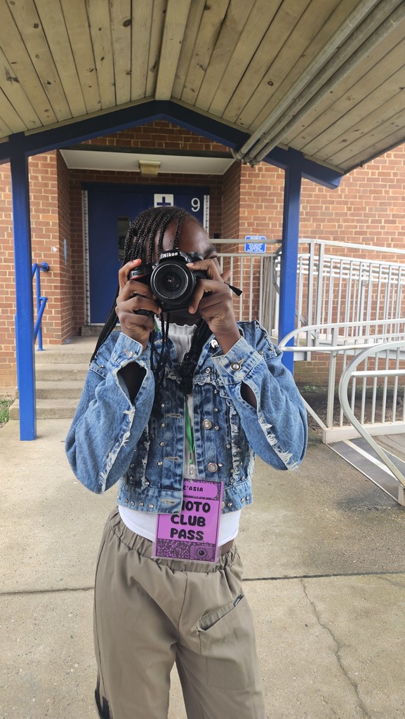 Student looks at camera through camera.