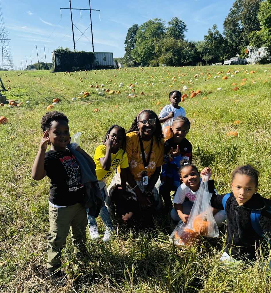 Students and Miss Parham stand in the pumpkin patch field.