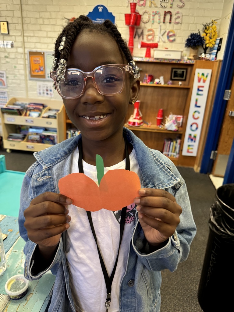 A student shows the pumpkin she created.