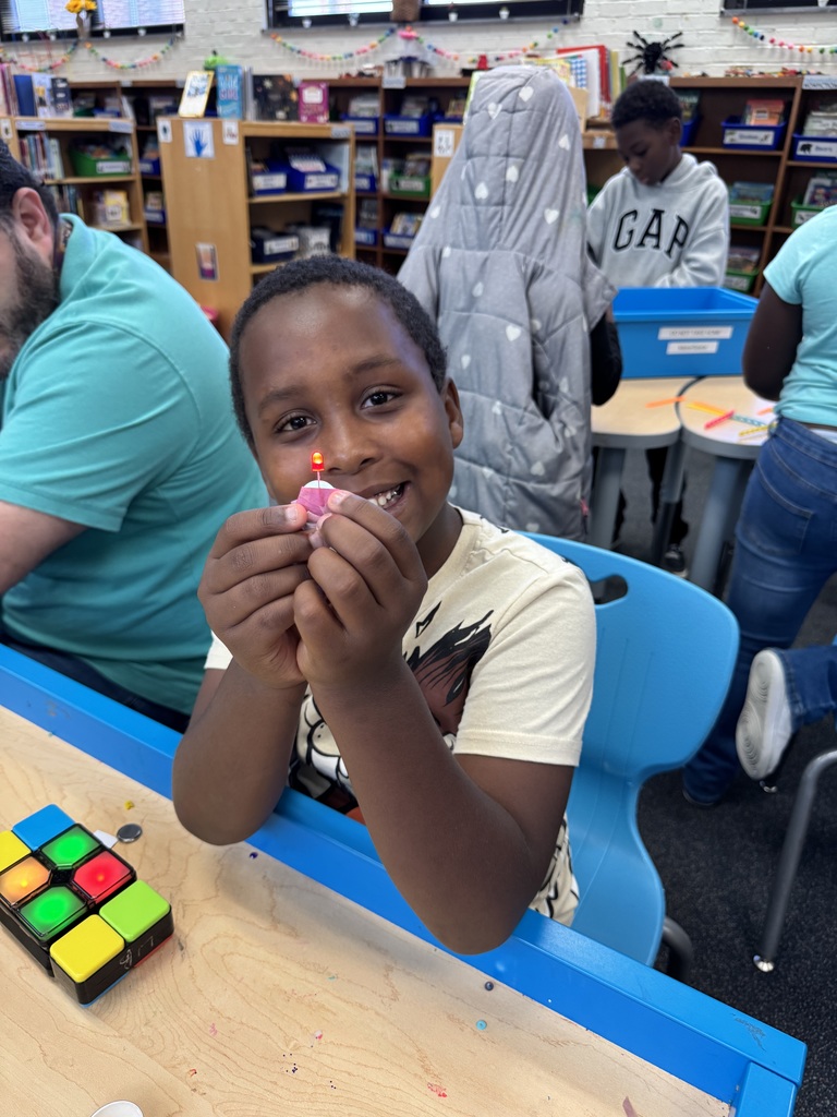 Student holds up their circuit.