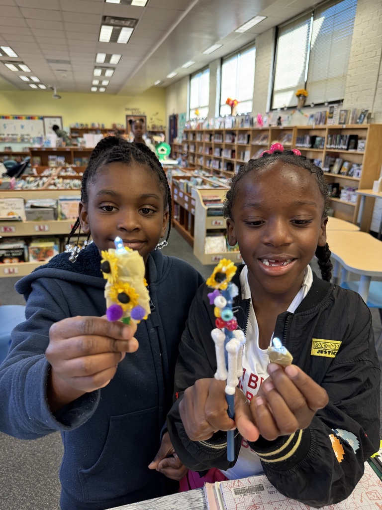 2 students showcase the lights they made.