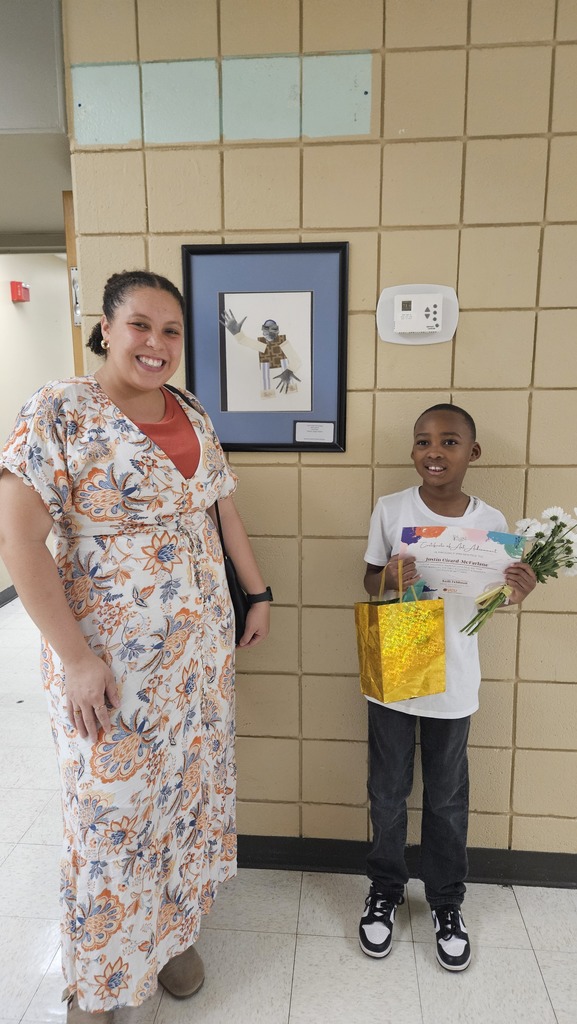 Student stands with Ms. Mason to celebrate his work.