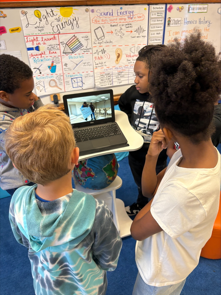 Student shows his presentation to fourth graders.
