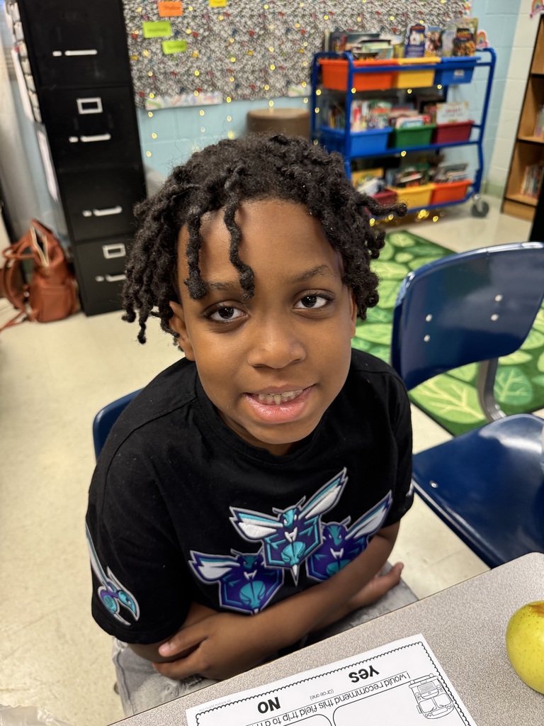 A student shows off his jersey in the classroom.