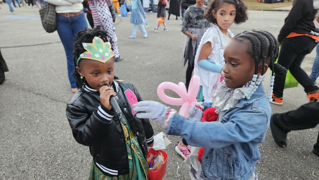 Student sharing a microphone at Trunk or Treat.