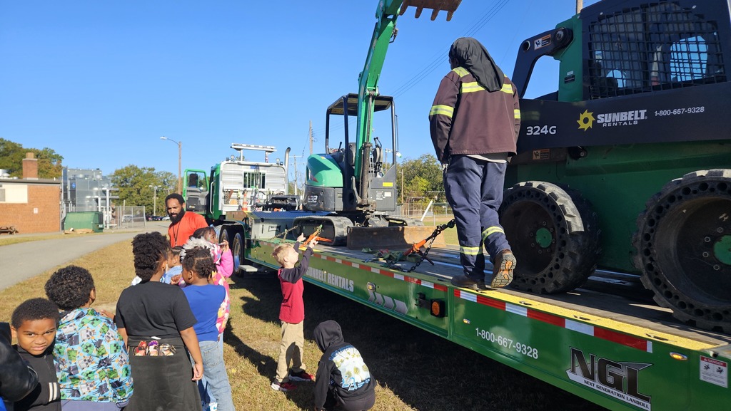 Students ask questions about different construction vehicles. 