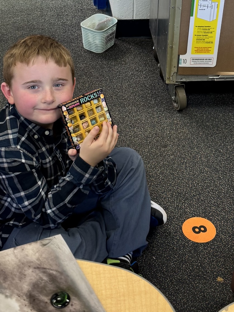 Students shows a rock collection that he selected for Wish Day.
