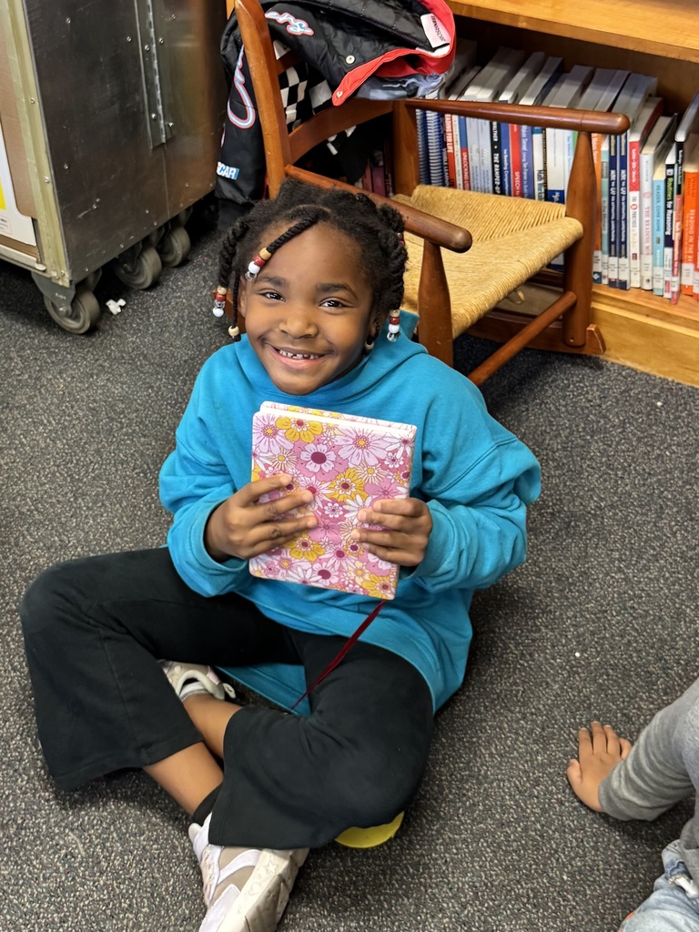 Student holds up a journal that she selected for Wish Day.