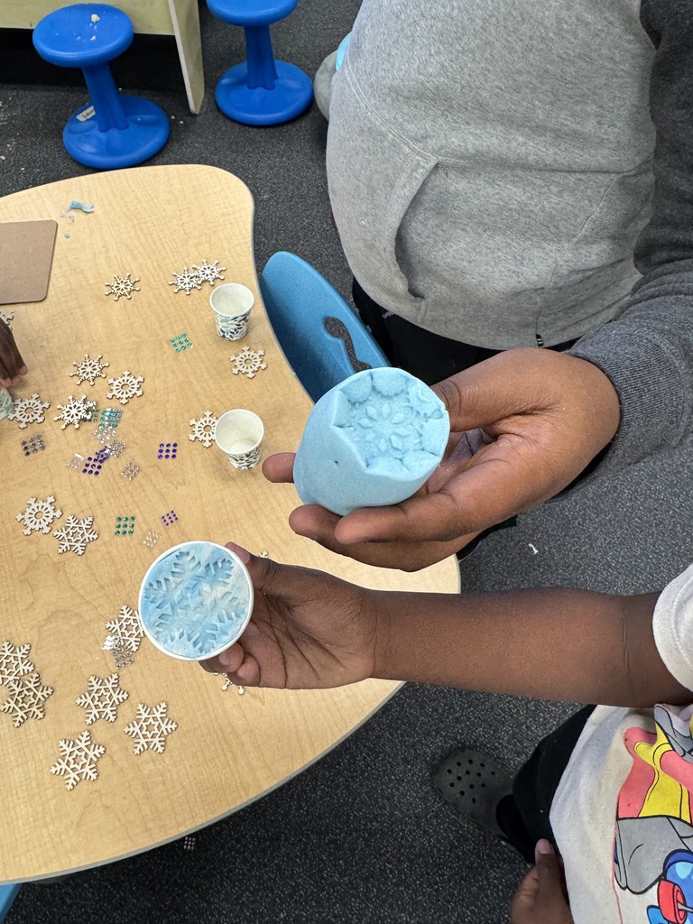 Student makes snowflake designs with stencils and sand.
