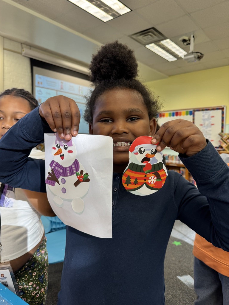 Student shows off the snow people they created.