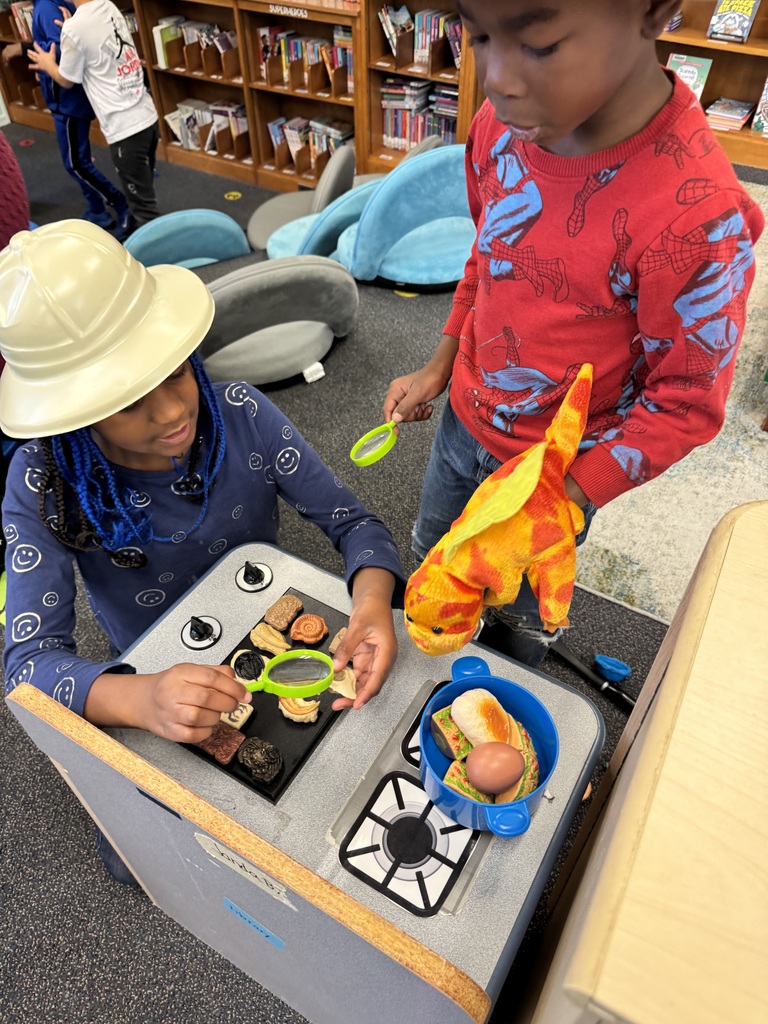 Students explore dinosaur fossils and dinosaur puppets.