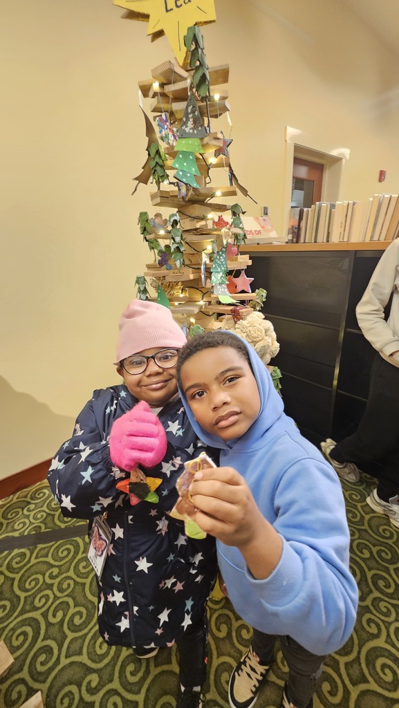 Two students hold up their ornaments.