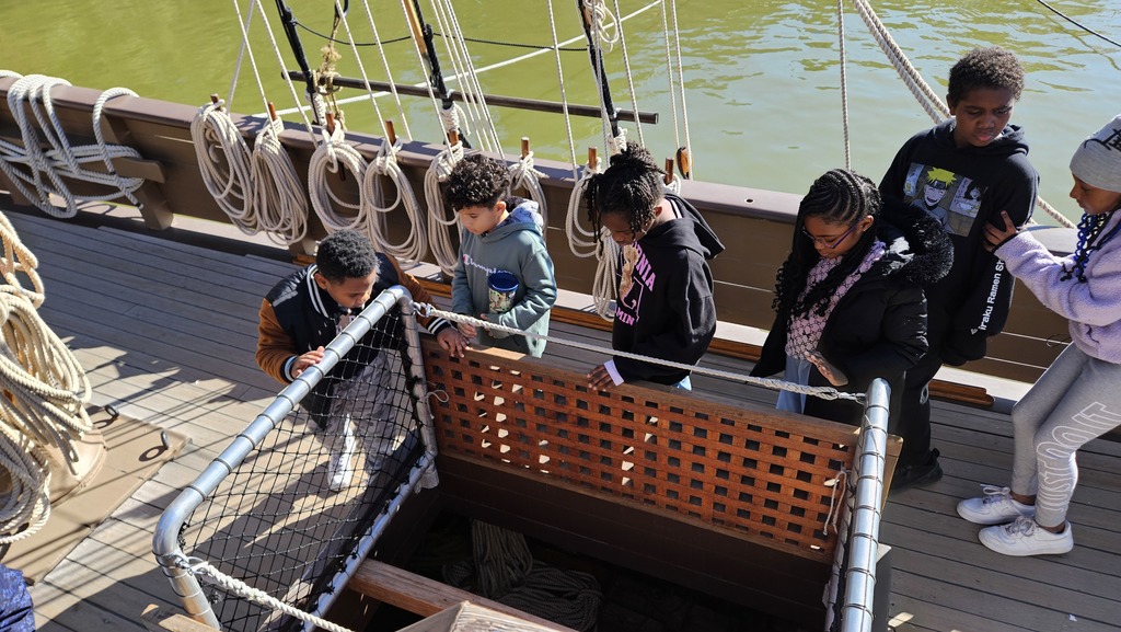 Students walk around a replica of one of the original ships.