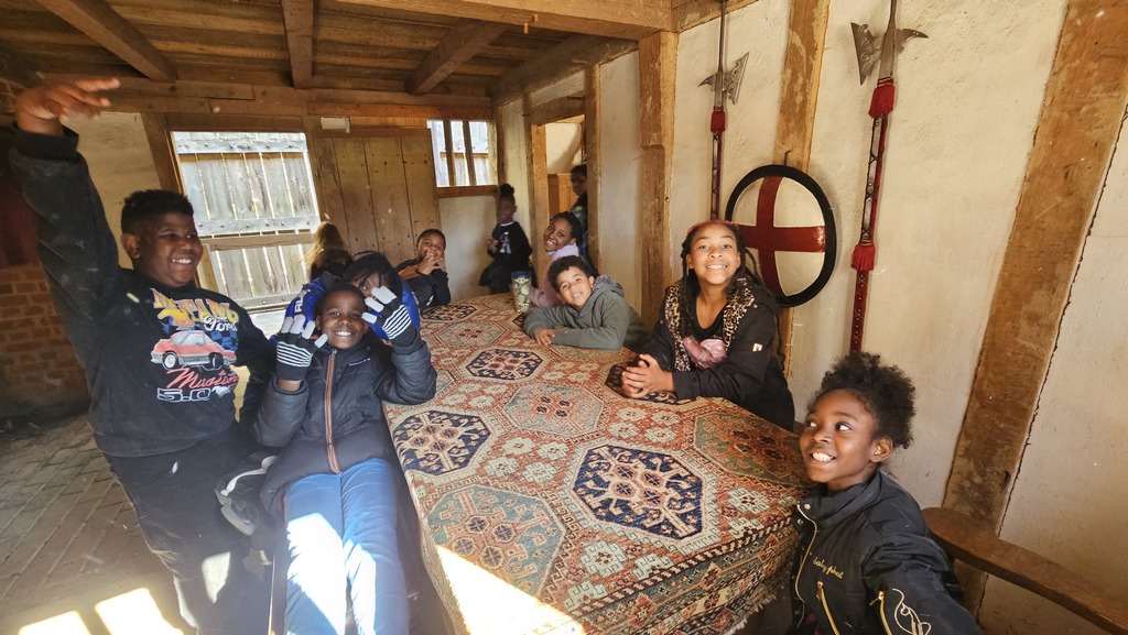 Students pose at a table inside a Jamestown home.