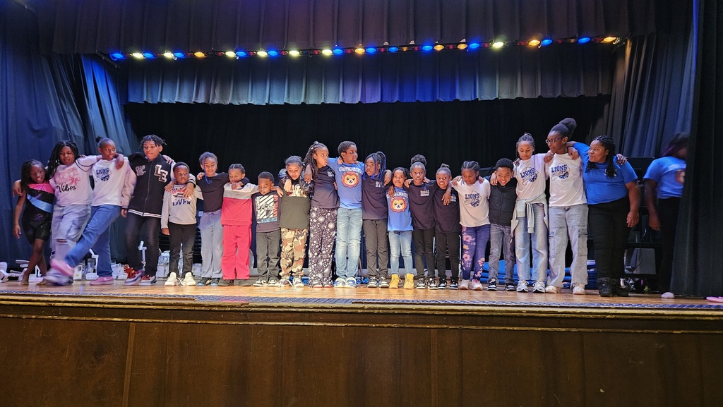 All students stand on stage together.