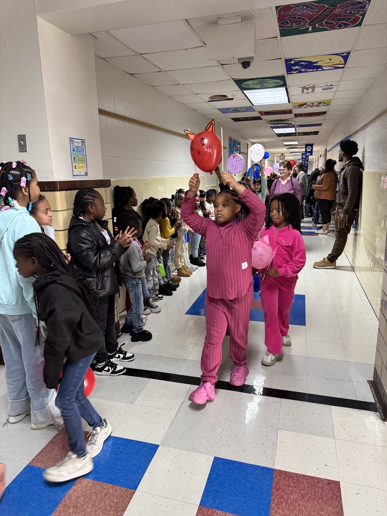 Students walk the hall with their balloons.