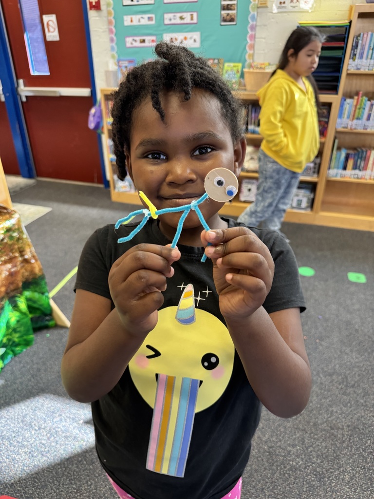 Student shows a dinosaur they created.