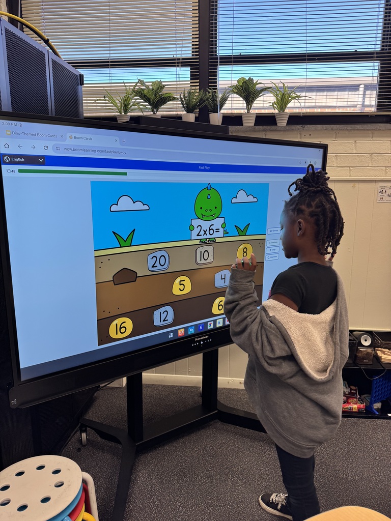 Student practices multiplication on the board.