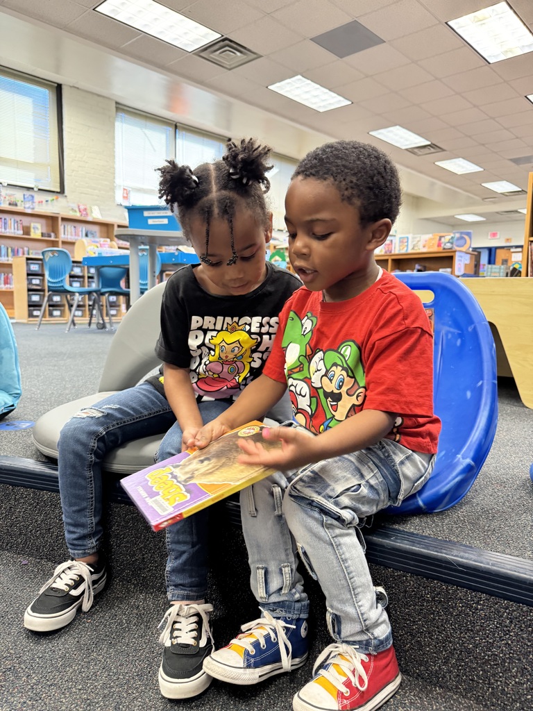 Preschoolers look at a nonfiction book together.