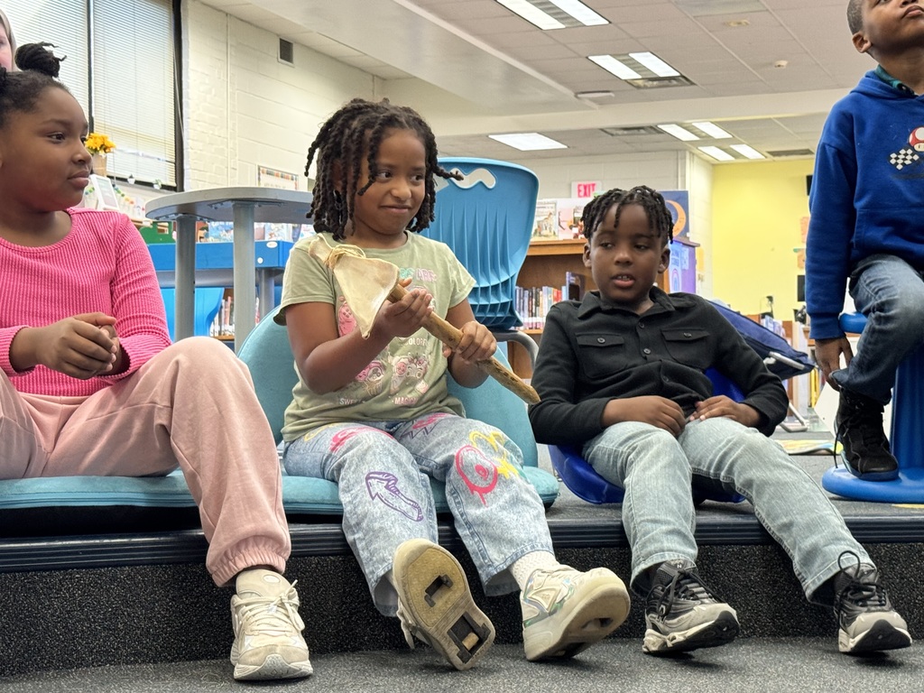 Two students hold and examine a tool.