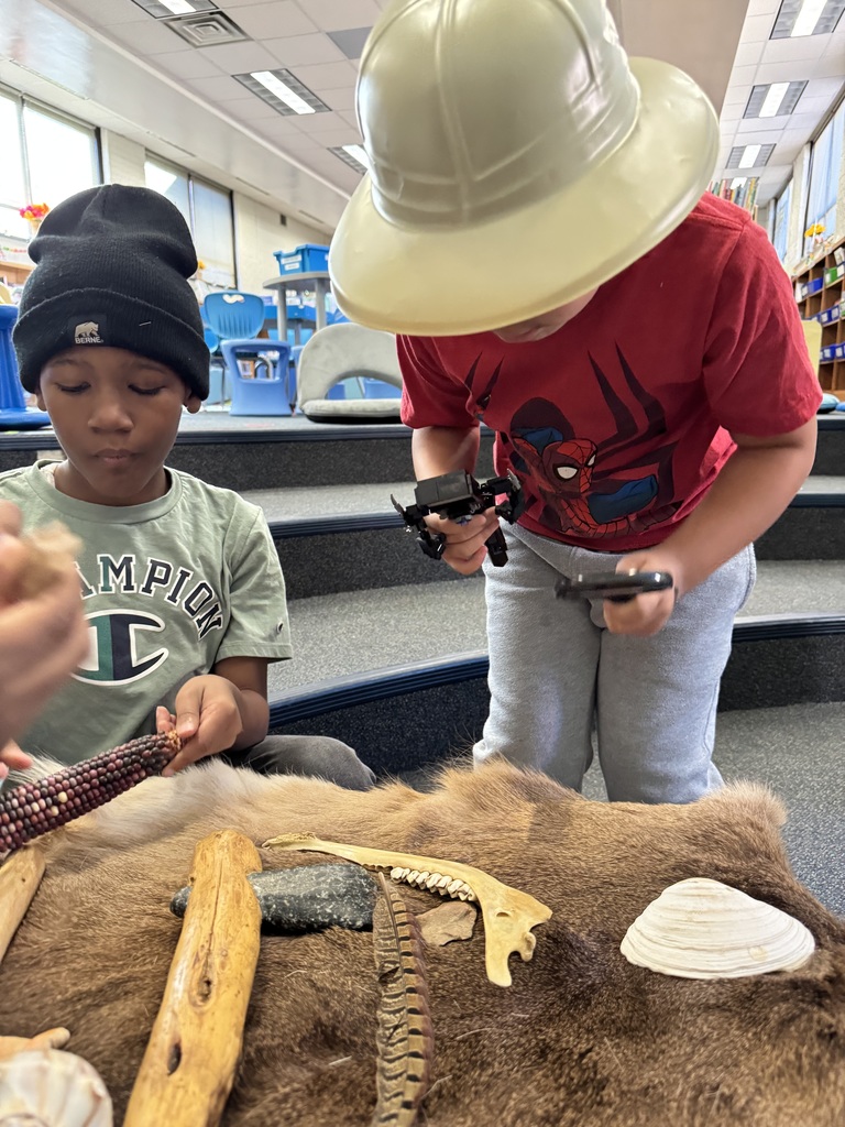 Students examine artifacts with their hands and the magnifying glass.