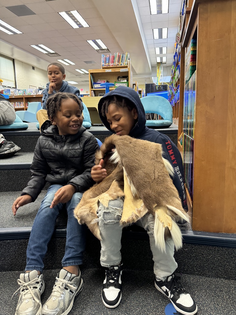 Students hold and touch a deer hide.