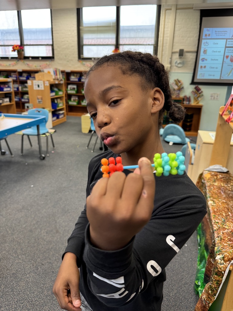 Student shows off a tiny weight he built.