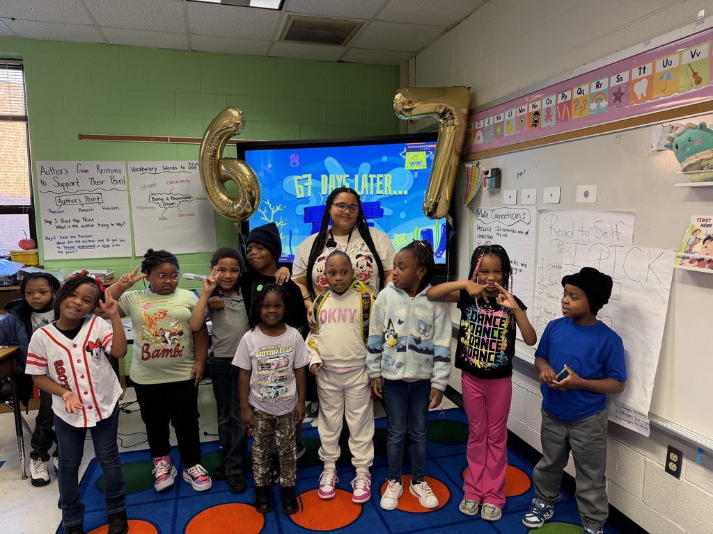 Students and teacher stand in front of 67 days later board.