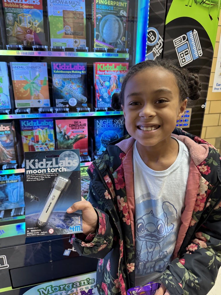 Third grade student holds up a flashlight she selected.