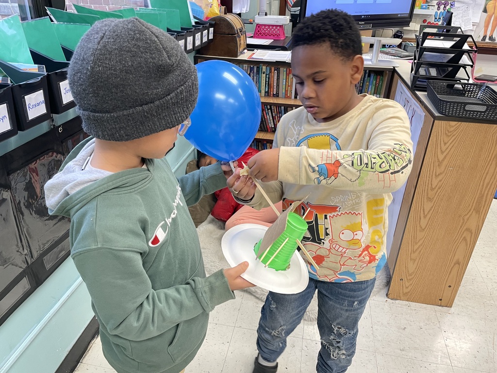 Students work together to attach their balloon.