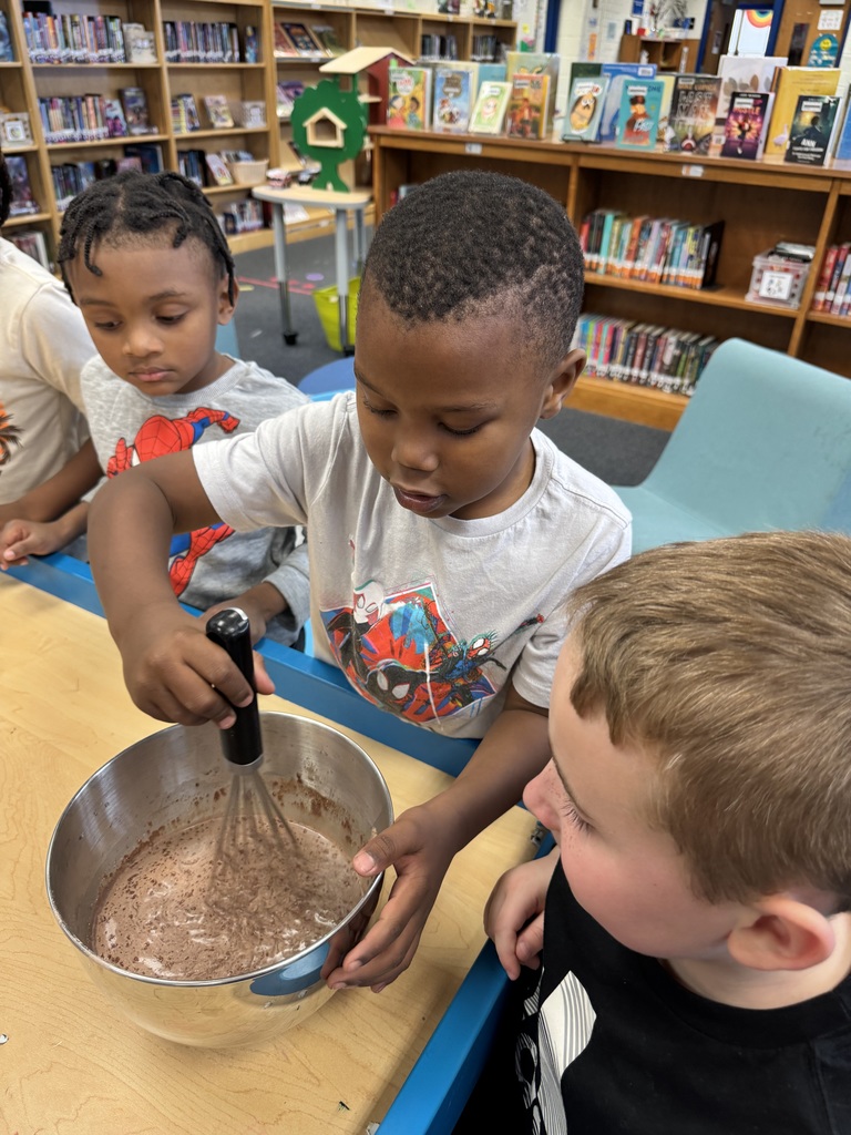 Students mix hot cocoa into a bowl.