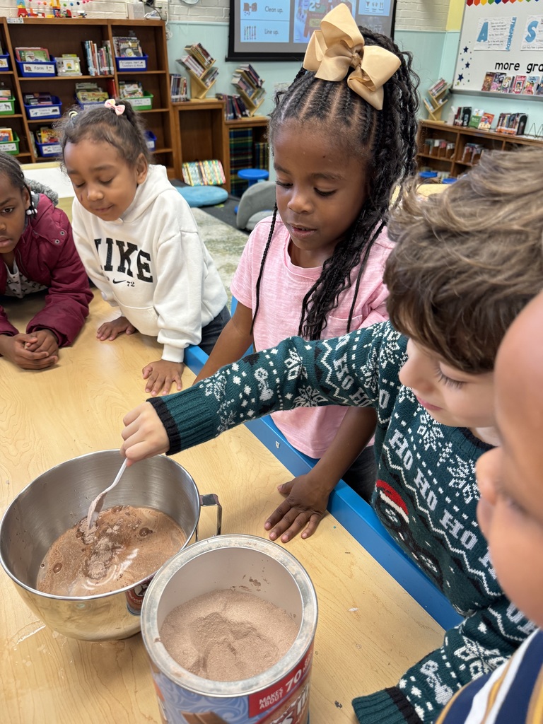 Students take turns to add hot cocoa.