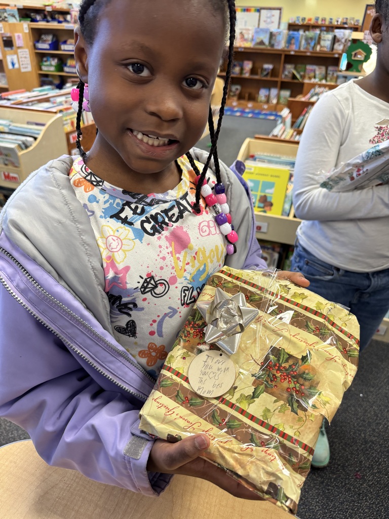 Student holds up a gift she made for her mom.