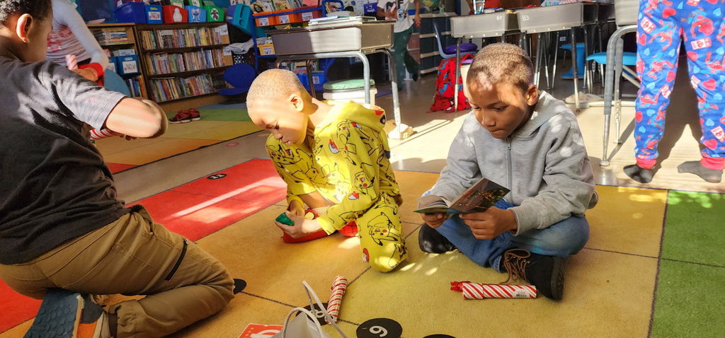 Students read books and look through kaleidoscopes.